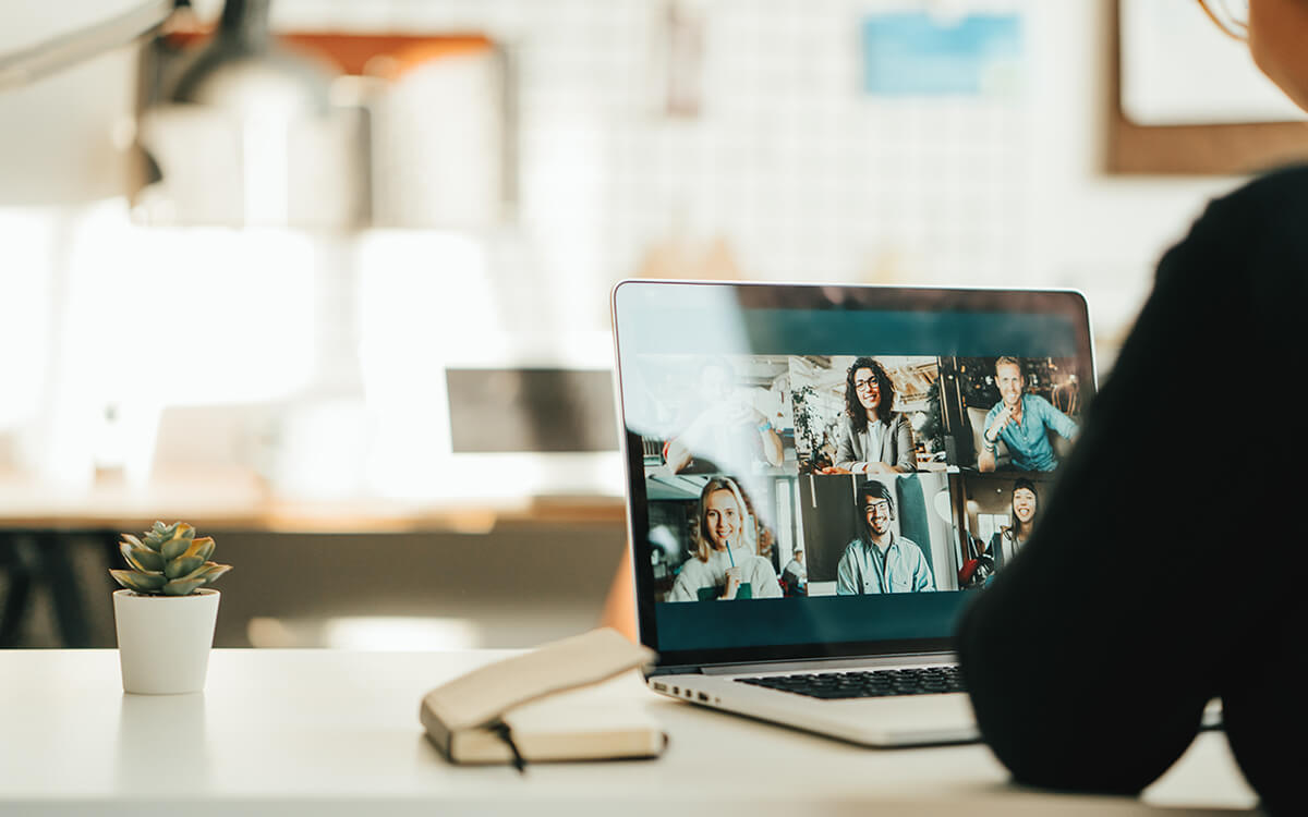 Eine Frau nimmt am Laptop an einem Online-Meeting teil