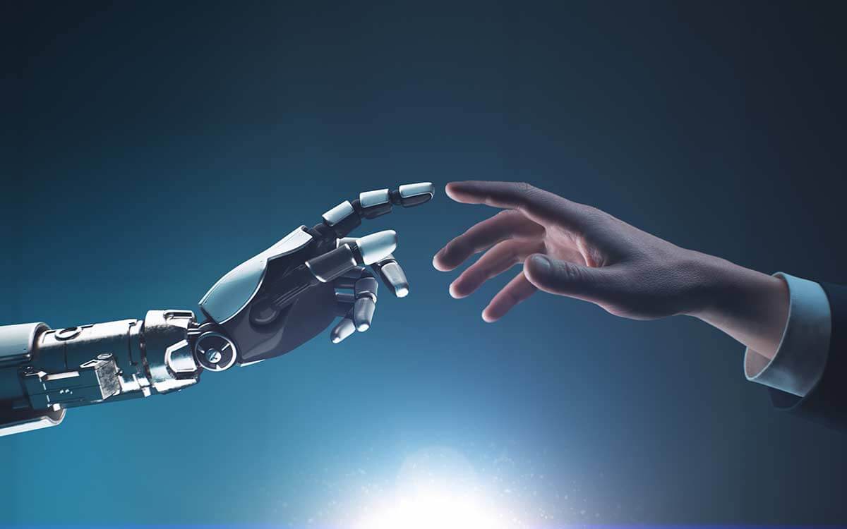 Gegenüberstellung einer Roboterhand mit einer menschlichen Hand als Symbol für KI