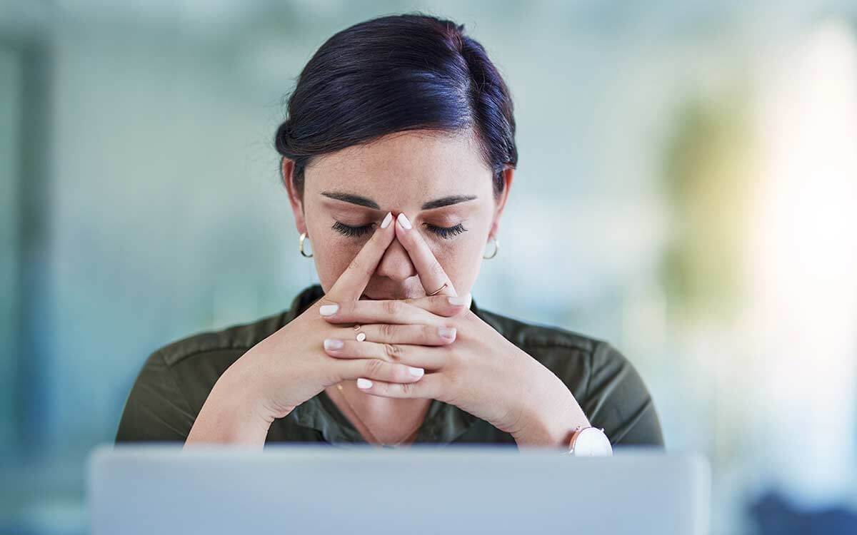 Frau sitzt am Laptop mit sorgenvollem Blick