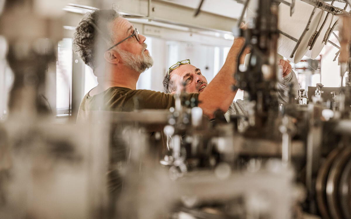 Zwei Männer bedienen eine industrielle Nähmaschine