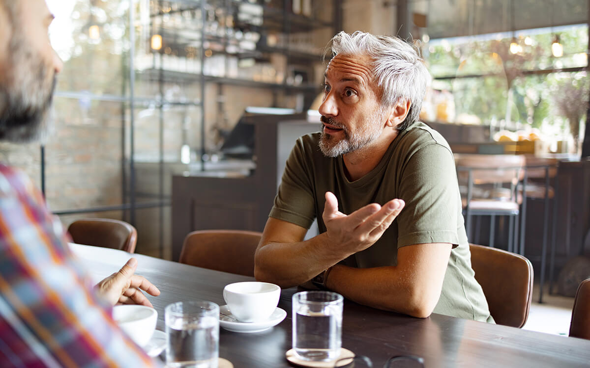 Zwei Männer im Café diskutieren miteinander