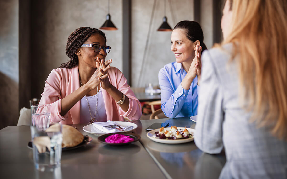 Drei Damen unterhalten sich im Café