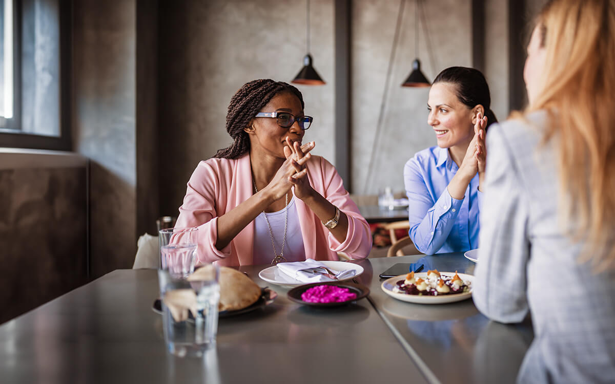 Drei Damen unterhalten sich im Café