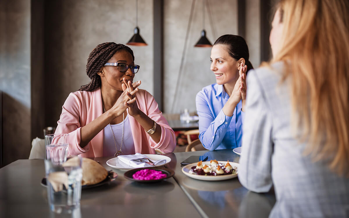 Drei Damen unterhalten sich im Café