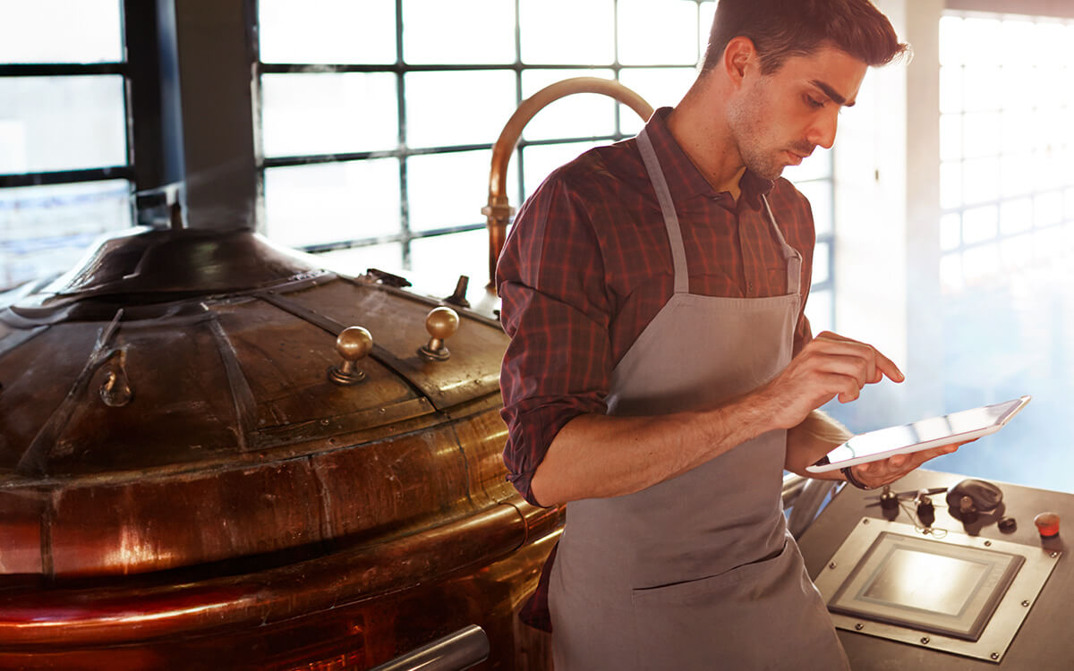 Ein Bierbrauer bedient ein Tablet