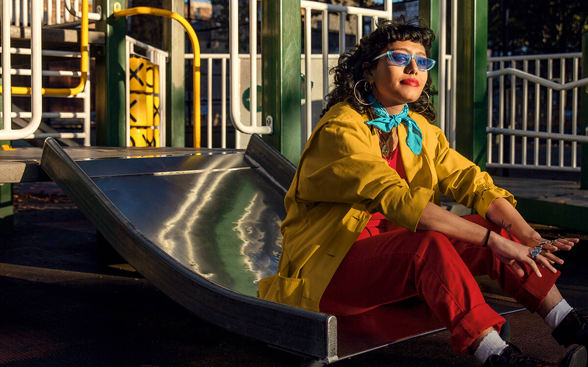 Ein Frau mit Sonnenbrille sitzt auf einer Rutsche