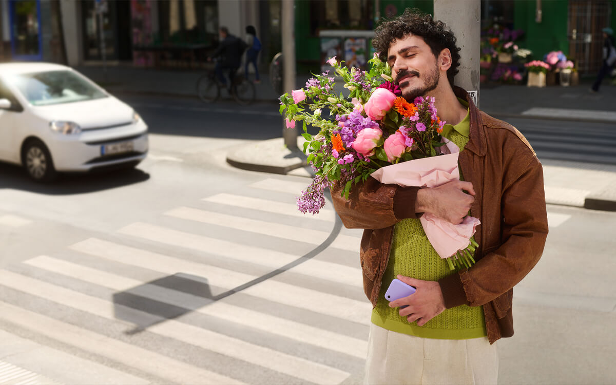 Ein verliebter Mann mit einem Blumenstrauß überquert eine Straße