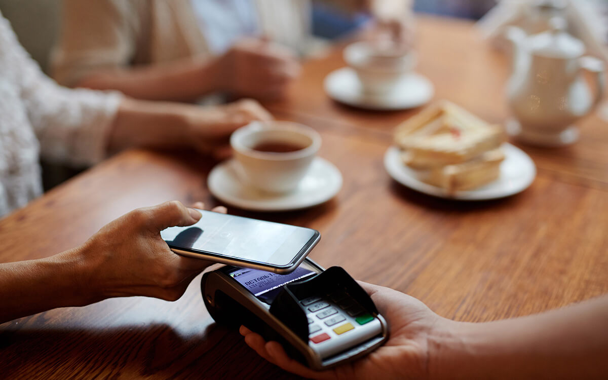 Symbolbild: Mobil bezahlen in einem Café