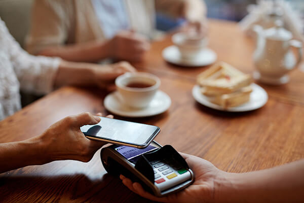 Symbolbild für mobiles Bezahlen in einem Café