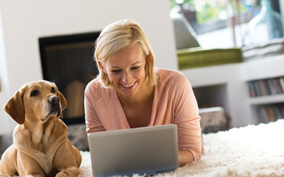 Dame und Hund liegen auf dem Teppich vor dem Kamin